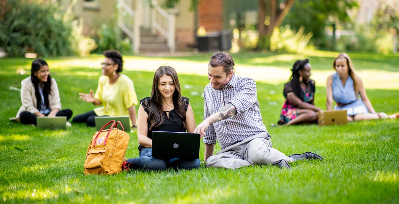 Image shows MHA students outside working together on a computer. The image is decorative.