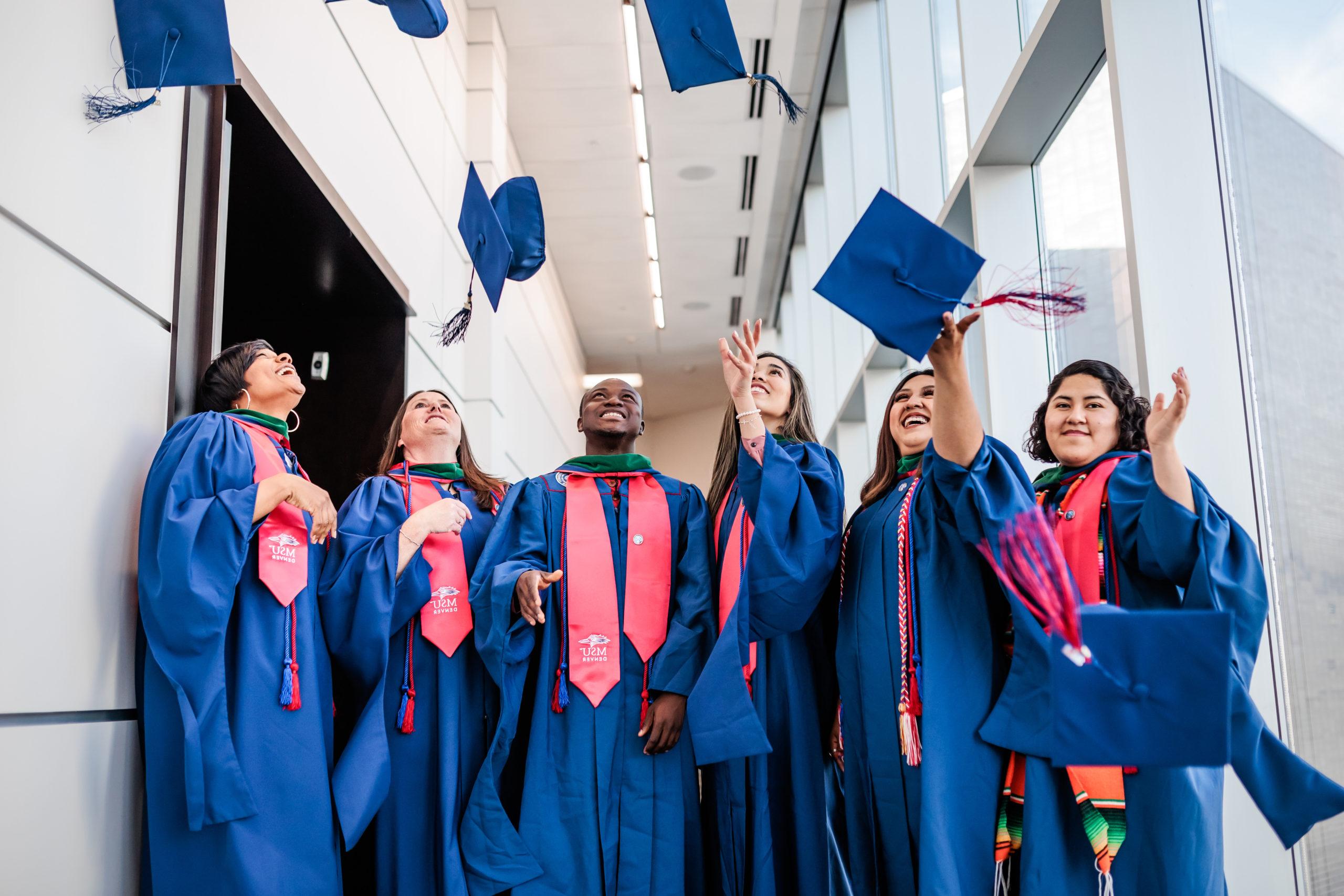 This photo shows the MHA Spring 22 graduating Class Photo. The students are in their graduation regalia and tossing their caps in the air. The image is decorative only.